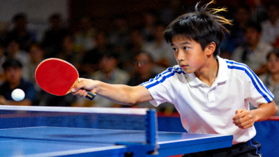 16岁乒乓球新星张锐在比赛中专注发球，眼神坚定