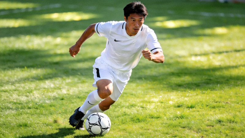 李明在绿茵场上进行带球突破训练，神情专注，动作流畅