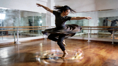 青年舞者陈默在舞蹈室中完成一个高难度的现代舞旋转动作