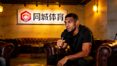一位知名球星坐在采访间，背景是同城体育的logo，正在接受深度专访