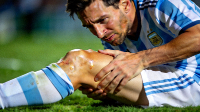 足球巨星梅西在训练中手扶膝盖面露不适的伤病特写照片